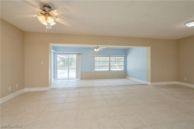 unfurnished room with ceiling fan and light tile flooring