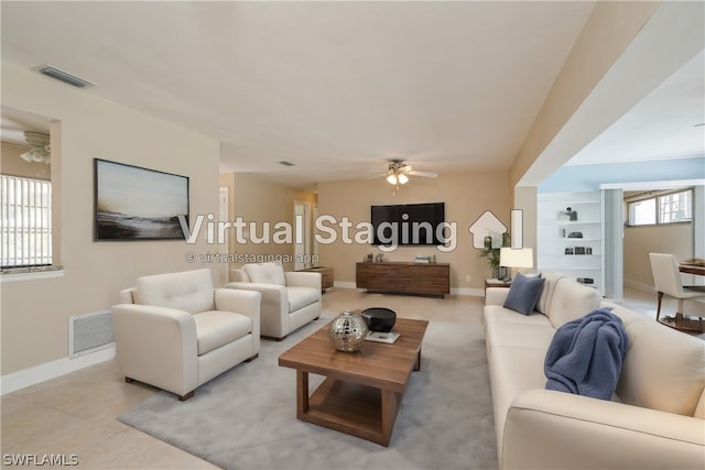 living room with built in features, ceiling fan, and light tile floors