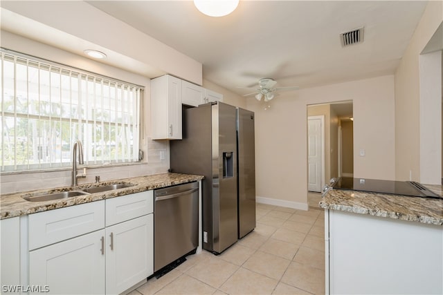 kitchen featuring appliances with stainless steel finishes, ceiling fan, light tile flooring, white cabinetry, and sink