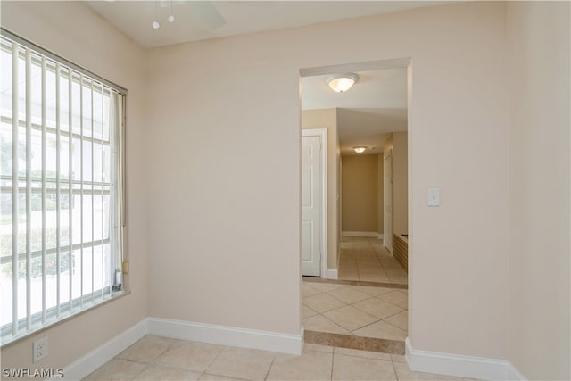 tiled spare room with plenty of natural light and ceiling fan