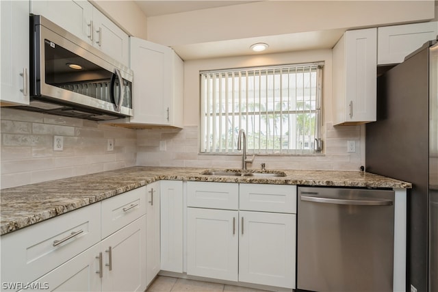 kitchen with white cabinets, tasteful backsplash, and stainless steel appliances