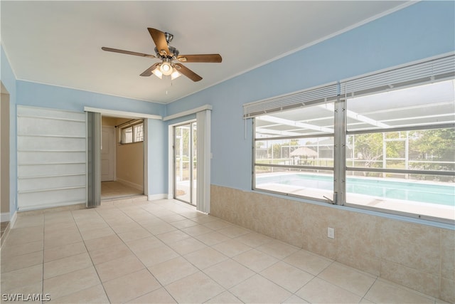 spare room with ceiling fan, light tile floors, and built in shelves