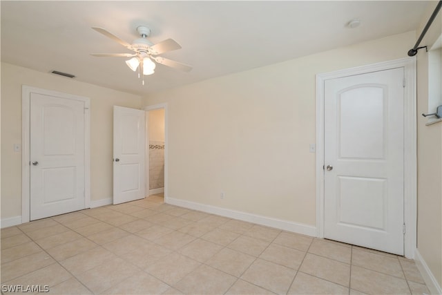 unfurnished bedroom with ceiling fan and light tile floors