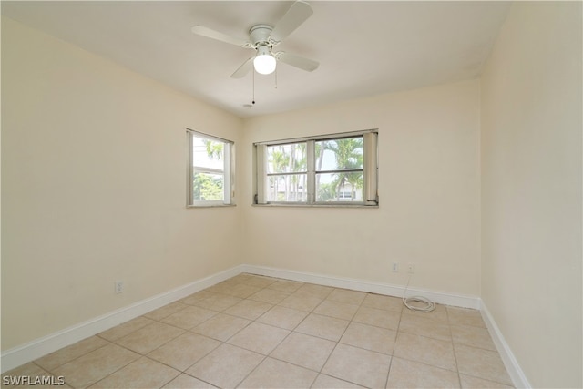 tiled spare room featuring ceiling fan and a healthy amount of sunlight