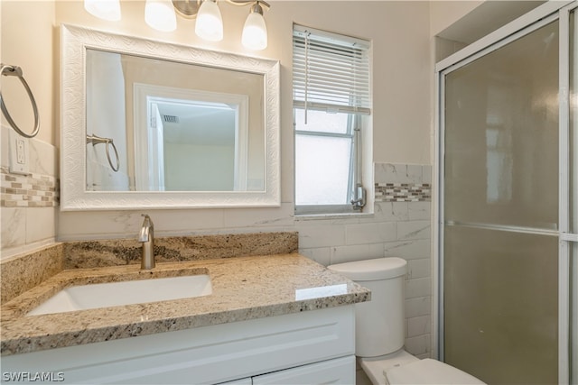 bathroom featuring vanity, an enclosed shower, toilet, and tile walls