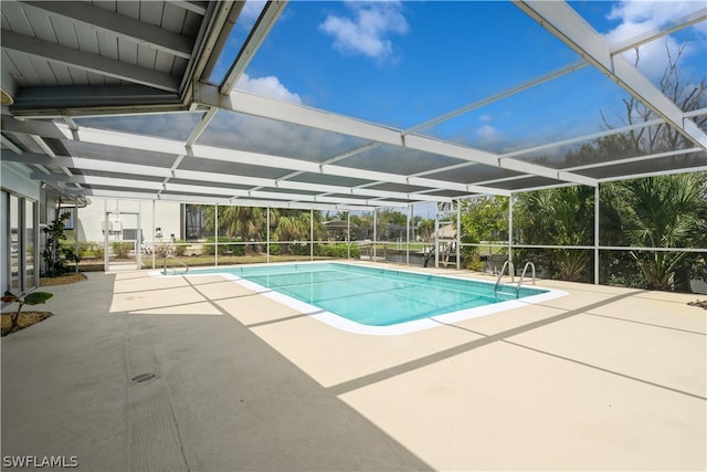 view of pool with a patio and glass enclosure