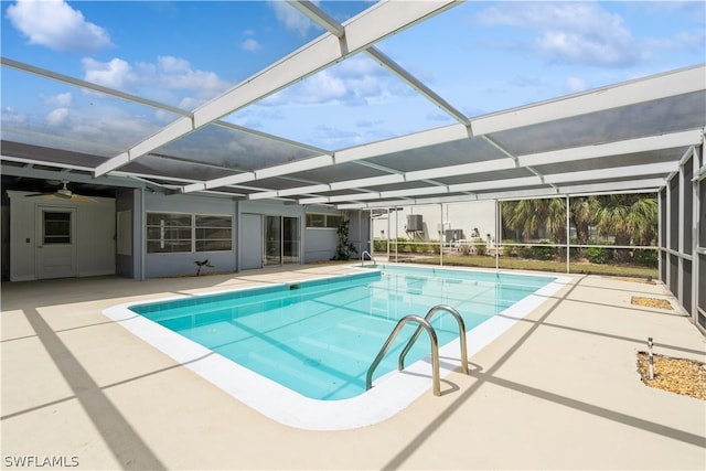 view of pool featuring glass enclosure, ceiling fan, and a patio area