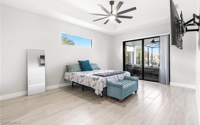 bedroom featuring light hardwood / wood-style floors, ceiling fan, and access to outside