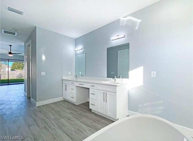 bathroom featuring dual vanity, wood-type flooring, ceiling fan, and a bathtub