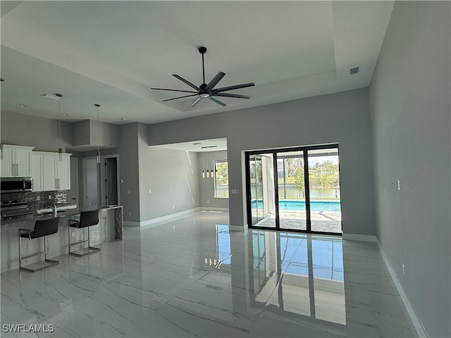 kitchen featuring white cabinetry, a raised ceiling, a breakfast bar, and electric range