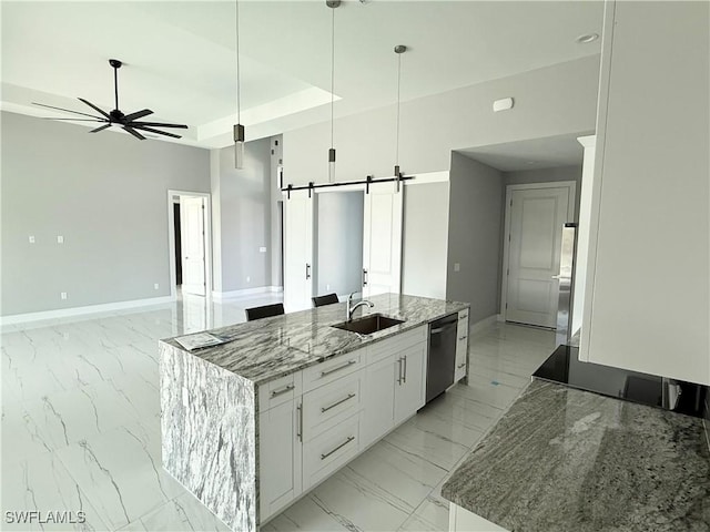 kitchen with white cabinetry, an island with sink, a barn door, light stone countertops, and dishwasher