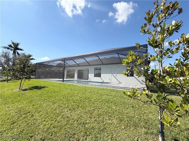 rear view of house with glass enclosure and a lawn