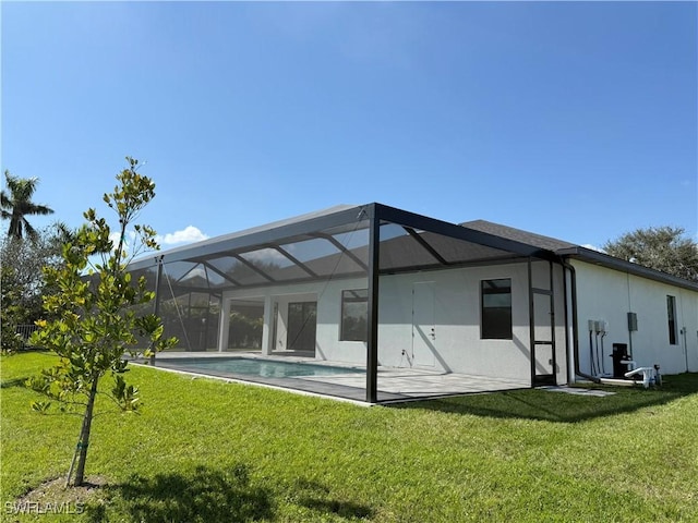 rear view of house featuring a lanai and a lawn