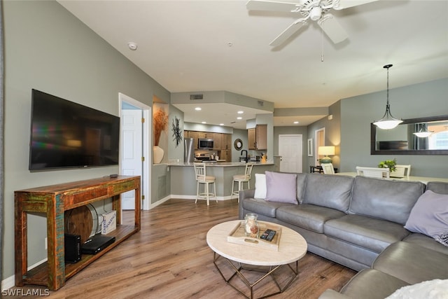 living room with wood-type flooring and ceiling fan