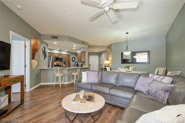 living room with wood-type flooring and ceiling fan