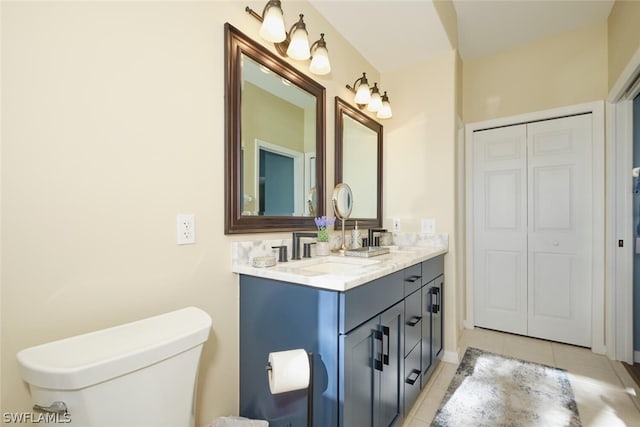 bathroom with toilet, tile flooring, and vanity