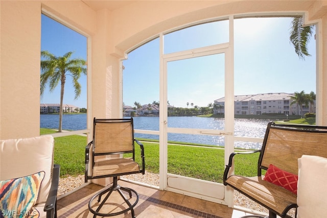 sunroom featuring a water view and a healthy amount of sunlight