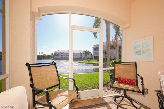 sunroom featuring a water view and a healthy amount of sunlight