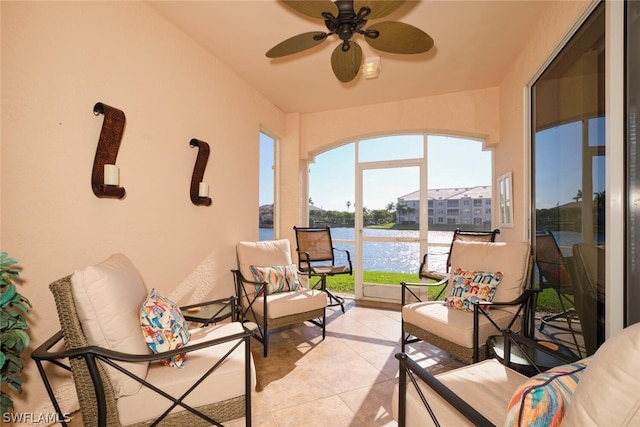 sunroom / solarium featuring ceiling fan, a water view, and plenty of natural light