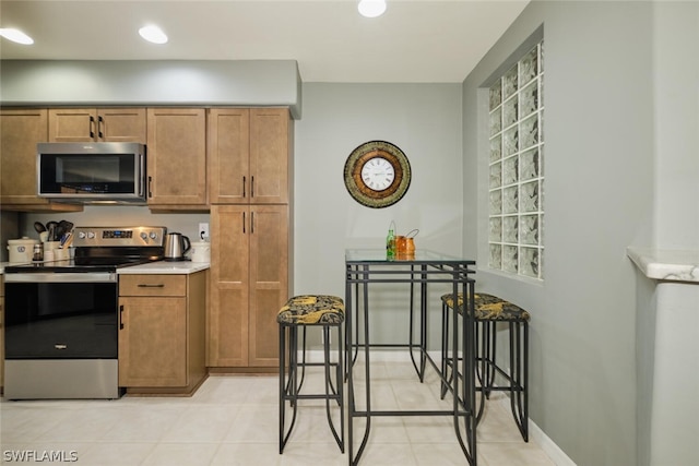 kitchen with appliances with stainless steel finishes and light tile floors