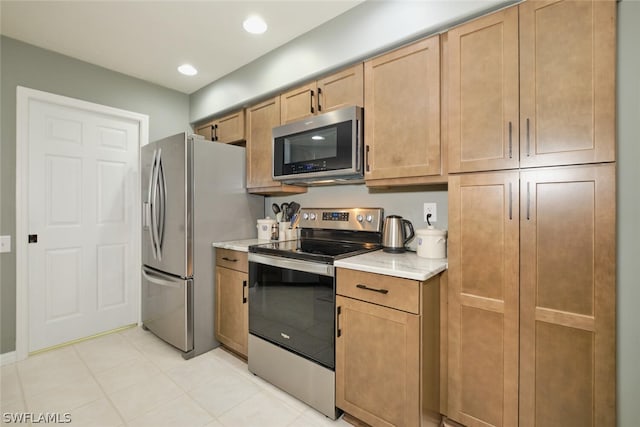 kitchen featuring light tile floors and stainless steel appliances