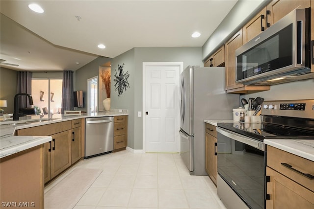 kitchen featuring stainless steel appliances, sink, and light tile flooring