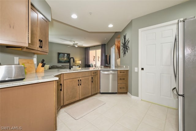 kitchen featuring kitchen peninsula, appliances with stainless steel finishes, ceiling fan, sink, and light tile floors