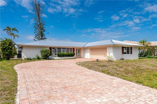 ranch-style home featuring central AC, a front lawn, and a garage