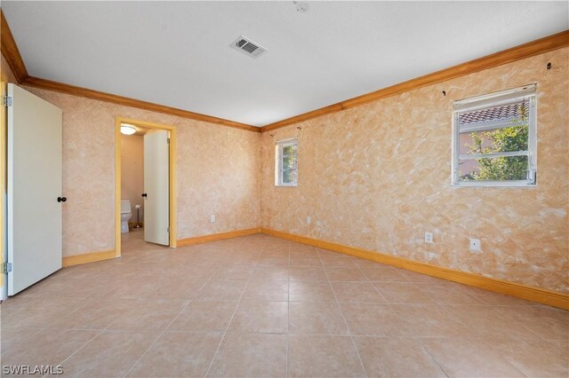 empty room featuring crown molding