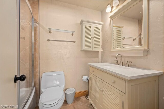 full bathroom with combined bath / shower with glass door, vanity, tile patterned flooring, and toilet