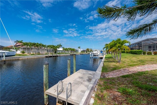 dock area featuring a lawn and a water view