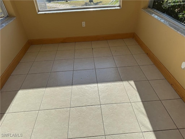 spare room with light tile patterned floors and a wealth of natural light