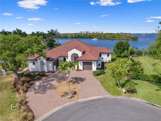 mediterranean / spanish-style house featuring a garage, a front yard, and a water view