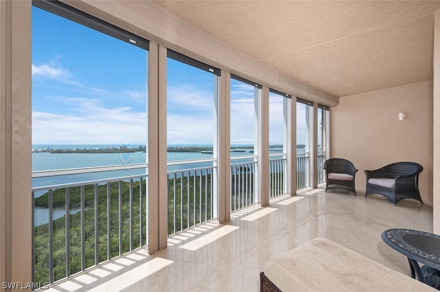 sunroom / solarium featuring a water view