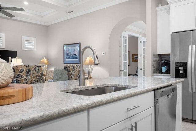 kitchen featuring light stone counters, stainless steel appliances, white cabinetry, and sink