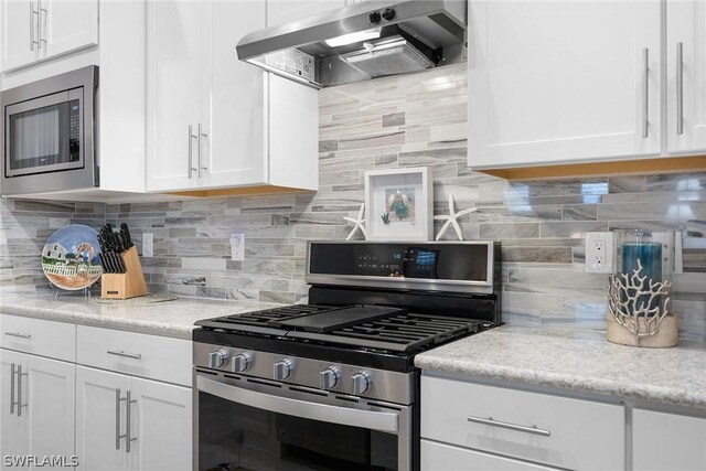 kitchen with ventilation hood, white cabinetry, backsplash, and appliances with stainless steel finishes