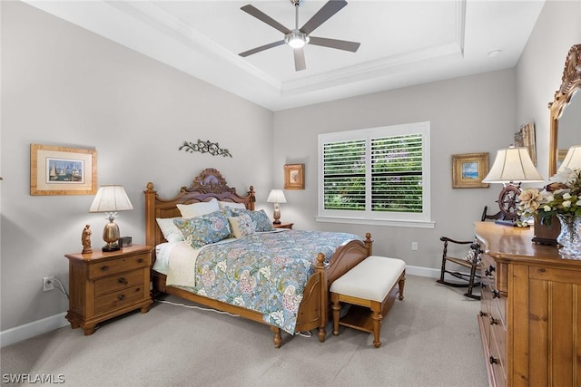 carpeted bedroom featuring ceiling fan and a raised ceiling