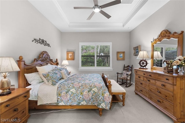 carpeted bedroom with ceiling fan, a raised ceiling, and crown molding