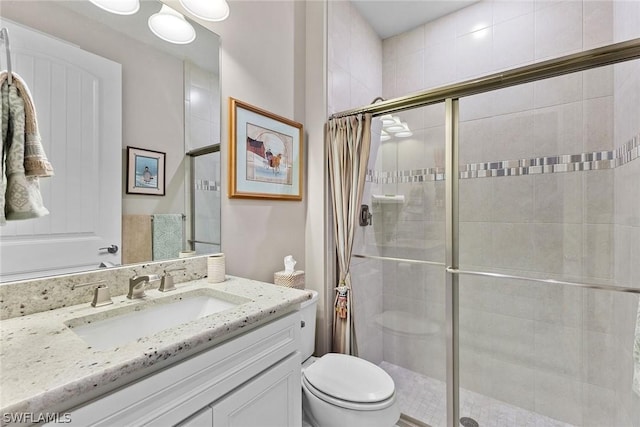 bathroom with toilet, a shower with shower door, and vanity