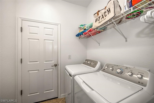 clothes washing area featuring light tile floors and washing machine and clothes dryer