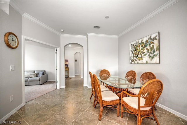 carpeted dining room featuring ornamental molding