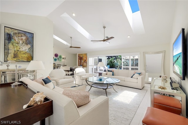 tiled living room with ceiling fan and vaulted ceiling with skylight