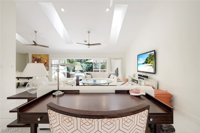 living room featuring tile floors, ceiling fan, and vaulted ceiling with skylight