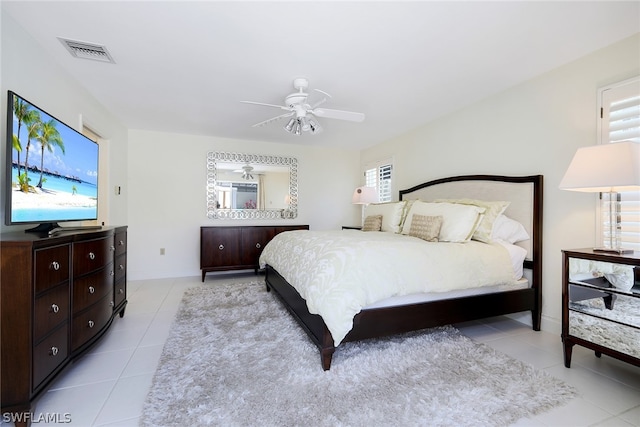 bedroom with ceiling fan, light tile floors, and multiple windows