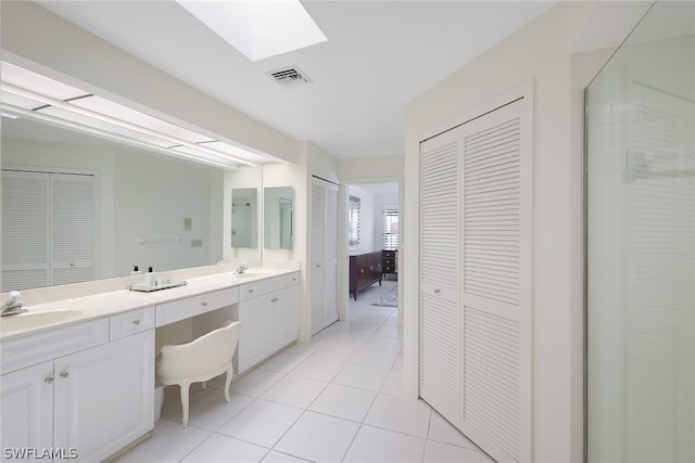 bathroom with a skylight, tile flooring, and double vanity