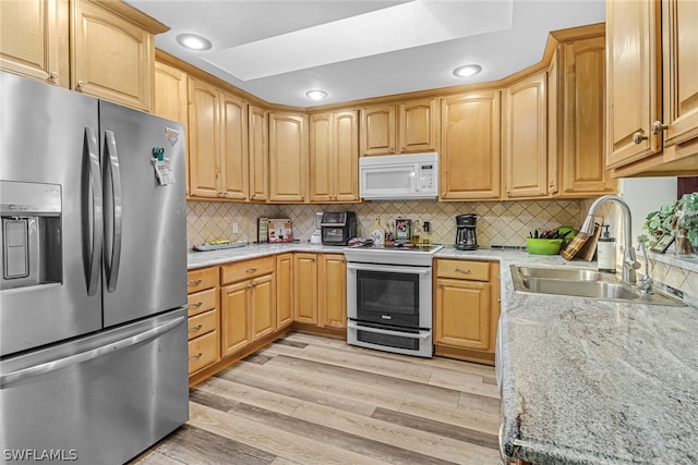 kitchen with stainless steel fridge with ice dispenser, range with two ovens, light hardwood / wood-style flooring, tasteful backsplash, and sink