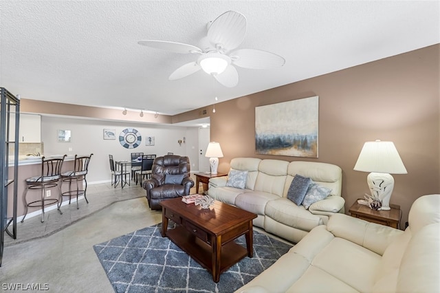 living room with ceiling fan, rail lighting, and a textured ceiling