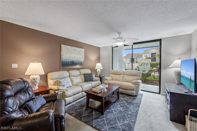 living room with dark colored carpet, ceiling fan, and a textured ceiling