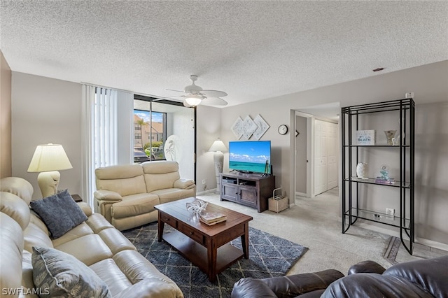 living room with carpet flooring, ceiling fan, and a textured ceiling