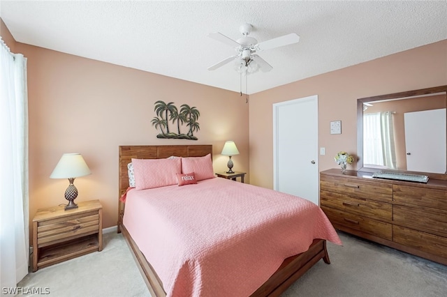 carpeted bedroom with ceiling fan and a textured ceiling